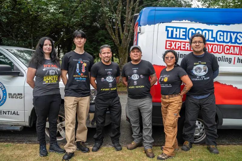 The six-person Cool Guys crew standing together beside their work vehicles.